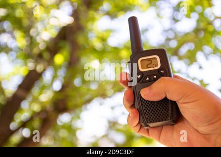 Handheld Walkie Talkie für den Außenbereich. Walkie Talkie in den Händen des jungen Mannes. Stockfoto