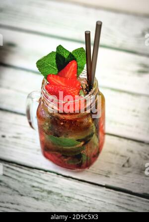 Hausgemachter Erdbeer Eistee in einem Glas auf einem Holz Weißer Tisch Stockfoto