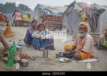 Allahabad, Indien, November 2015. Zwei Frauen und ein Sadhu bereiten im Lager, wo sie am Zusammenfluss des Yamuna-Flusses mit der Gange leben, Nahrung zu Stockfoto
