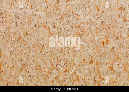 OSB, Boardstruktur und Hintergrundaus gepressten sandigen braunen Holzspänen, Nahaufnahme. Stockfoto