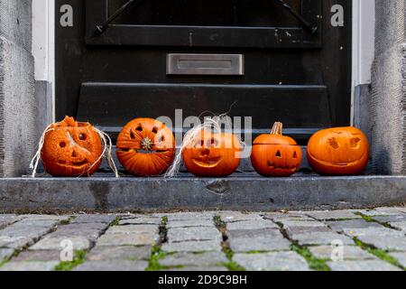 5 Kürbisse auf der Stufe einer Eingangstür in Maastricht. Die Menschen in Europa beginnen, Halloween jedes Jahr mehr einschließlich der amerikanischen Traditionen zu feiern Stockfoto