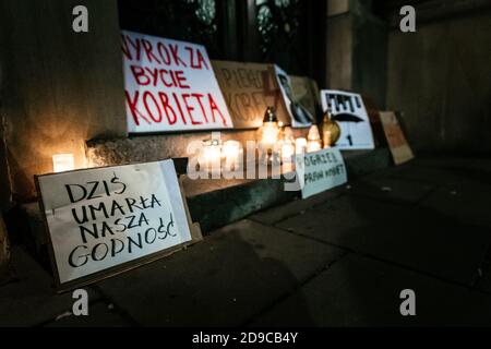 Plakate und Friedhofskerzen, die von Demonstranten am Eingang des Büros der Regierungspartei Recht und Gerechtigkeit in Krakau aufgestellt wurden. Im Vordergrund das sl Stockfoto