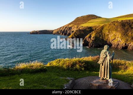 Ein Blick auf Ynys Lochtyn von den Cliffspitzen oberhalb von LLangrannog mit der Statue von St. Crannog im Vordergrund, Ceredigion, Wales Stockfoto