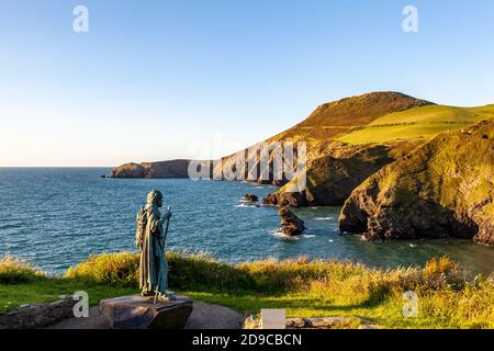 Ein Blick auf Ynys Lochtyn von den Cliffspitzen oberhalb von LLangrannog mit der Statue von St. Crannog im Vordergrund, Ceredigion, Wales Stockfoto