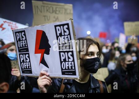 Ein Protestler trägt eine Maske hält ein Plakat mit einer roten Beleuchtung, ein Symbol für Women's Strike. Das polnische Verfassungsgericht in seinem neuen, politischen Cho Stockfoto