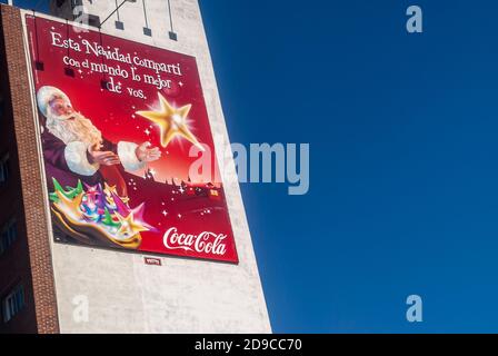 Montevideo, Uruguay- 18. Dezember 2008: Nahaufnahme des roten Coca-Cola weihnachtsbanners an der weißen Wand und flankiert von tiefblauem Himmel. Weihnachtsmann und gol Stockfoto