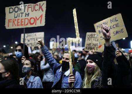 Eine Frau, die eine Maske trägt, eine Beleuchtung hält und ihre Faust in der Menge der Protestierenden hebt. Das polnische Verfassungsgericht in seiner neuen, politischen Stockfoto