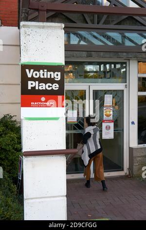 Frau, die ein Wahllokal oder Wahlplatz während der Provinzwahl am 24. Oktober 2020, Vancouver, British Columbia, Kanada betritt Stockfoto