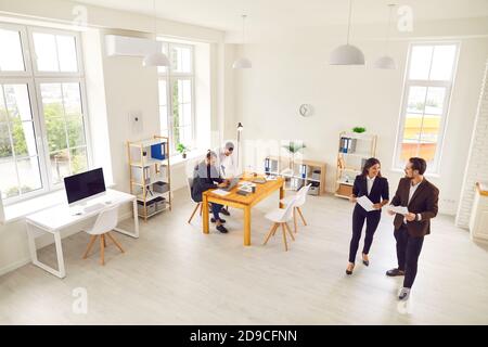 Junge Geschäftsleute teilen Ideen und arbeiten an Projekten in Moderne Büroflächen Stockfoto