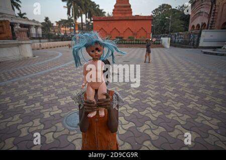 Kalkutta, Indien, Januar 2008. Ein Mädchen zeigt ihre zerbrochene Puppe auf einem Platz in Kalighat. Stockfoto
