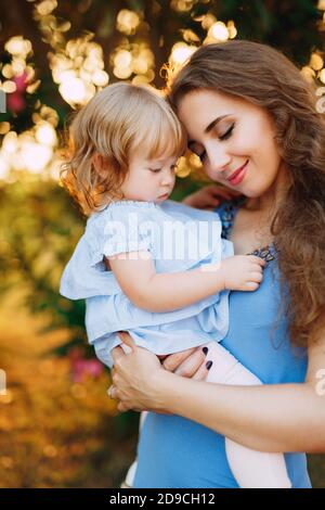 Mutter hält die kleine Tochter sanft in den Armen Stockfoto