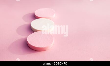 Kosmetikschwämme in Pastellfarben auf hellrosa Hintergrund. Stockfoto