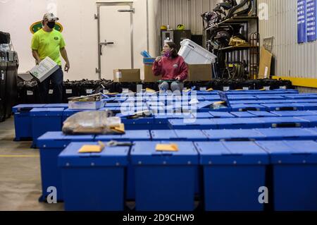 Altoona, Pennsylvania, USA. November 2020. Arbeiter brechen Wahlmaschinen und andere Materialien ab, die gestern in Blair County, Pennsylvania am 4. November 2020 zur Abstimmung verwendet wurden. Hinter den Kulissen zählen die Arbeiter die Stimmzettel, elektronisch und auf Papier, in einem privaten Raum. Wahlbeamte dort lehnten es ab, die Presse beobachten oder fotografieren die Tally Zimmer und Arbeiter zu lassen. Pennsylvania ist einer der Schlachtfelder Staaten für die amerikanischen Präsidentschaftswahlen und sagen, dass sie nicht haben Summen bis Freitag frühestens. Tim Boyles/Alamy Live News Stockfoto