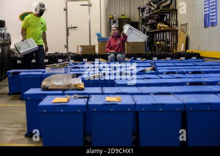 Altoona, Pennsylvania, USA. November 2020. Arbeiter brechen Wahlmaschinen und andere Materialien ab, die gestern in Blair County, Pennsylvania am 4. November 2020 zur Abstimmung verwendet wurden. Hinter den Kulissen zählen die Arbeiter die Stimmzettel, elektronisch und auf Papier, in einem privaten Raum. Wahlbeamte dort lehnten es ab, die Presse beobachten oder fotografieren die Tally Zimmer und Arbeiter zu lassen. Pennsylvania ist einer der Schlachtfelder Staaten für die amerikanischen Präsidentschaftswahlen und sagen, dass sie nicht haben Summen bis Freitag frühestens. Tim Boyles/Alamy Live News Stockfoto