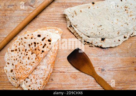 Traditionelle türkische Dorf Gebäck Pfannkuchen und Dorfbrot auf Holz Hintergrund. Neben einem hölzernen Nudelholz und Spatel. Stockfoto