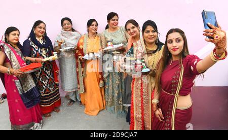 Beawar, Rajasthan, Indien, 4. November 2020: Indische verheiratete Frauen machen ein Selfie nach der Durchführung von Ritualen während Karwa Chauth (Ehemannstag) Festival Feiern in Beawar. Dieses traditionelle hinduistische Fest, das in Indien gefeiert wird, sieht verheiratete Frauen einen ganzen Tag fasten und dem Mond Gebete für Wohlergehen, Wohlstand und Langlebigkeit ihrer Ehemänner anbieten. Karva Chauth Festival feierte vier Tage nach Purnima (Vollmondtag) im hinduistischen heiligen Monat von Kartika. Kredit: Sumit Saraswat/Alamy Live Nachrichten Stockfoto