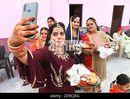 Beawar, Rajasthan, Indien, 4. November 2020: Indische verheiratete Frauen machen ein Selfie nach der Durchführung von Ritualen während Karwa Chauth (Ehemannstag) Festival Feiern in Beawar. Dieses traditionelle hinduistische Fest, das in Indien gefeiert wird, sieht verheiratete Frauen einen ganzen Tag fasten und dem Mond Gebete für Wohlergehen, Wohlstand und Langlebigkeit ihrer Ehemänner anbieten. Karva Chauth Festival feierte vier Tage nach Purnima (Vollmondtag) im hinduistischen heiligen Monat von Kartika. Kredit: Sumit Saraswat/Alamy Live Nachrichten Stockfoto