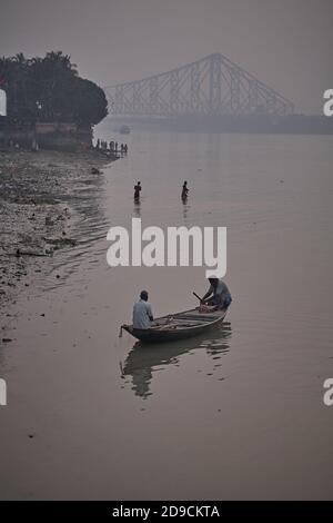 Kalkutta, Indien, Januar 2008. Ein Ruderboot bei Sonnenuntergang auf dem Ganges Fluss mit Howrah Brücke im Hintergrund. Stockfoto