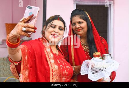 Beawar, Rajasthan, Indien, 4. November 2020: Indische verheiratete Frauen machen ein Selfie nach der Durchführung von Ritualen während Karwa Chauth (Ehemannstag) Festival Feiern in Beawar. Dieses traditionelle hinduistische Fest, das in Indien gefeiert wird, sieht verheiratete Frauen einen ganzen Tag fasten und dem Mond Gebete für Wohlergehen, Wohlstand und Langlebigkeit ihrer Ehemänner anbieten. Karva Chauth Festival feierte vier Tage nach Purnima (Vollmondtag) im hinduistischen heiligen Monat von Kartika. Kredit: Sumit Saraswat/Alamy Live Nachrichten Stockfoto