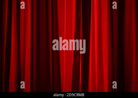Bukarest, Rumänien - 14. Juli 2020: Die Sonnenstrahlen beleuchten die Falten eines roten Vorhangs. Stockfoto