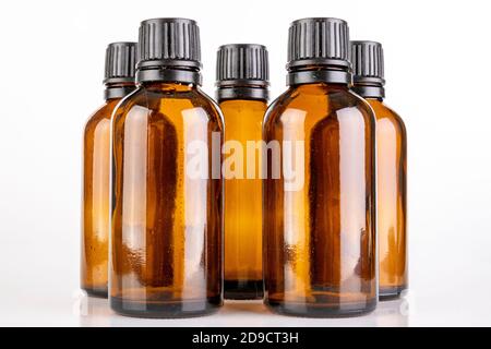 Kleine Glasflaschen zur Lagerung lichtempfindlicher Flüssigkeiten. Behälter, die in Pharmazeutika verwendet werden. Heller Hintergrund. Stockfoto
