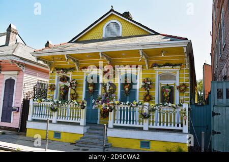 Ein traditionelles kreolisches Cottage in der St Ann Street im historischen French Quarter in New Orleans, Louisiana. Das gelbe Haus ist mit Blumen geschmückt. Stockfoto