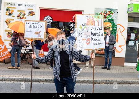 Gottingen, Deutschland. Herbst 2020. Freitags für die Zukunft. Junger Kaukasusmann hält während des Protestes Pfostenschilder auf der Straße. Dreiviertel Länge. Stockfoto