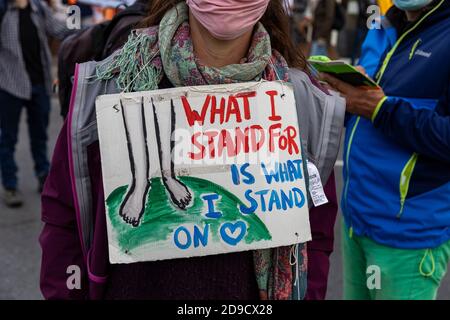 Anti-Klimawandel-Zeichen hängen am Hals des Protesters. Mittlere Aufnahme. Nicht erkennbare Person. Stockfoto