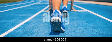 Sprinter fit Mann wartet auf Start des Rennens auf Laufstrecken im Outdoor-Stadion. Sport- und Fitnessläufer Athlet auf blauer Laufstrecke Startlinie mit Stockfoto