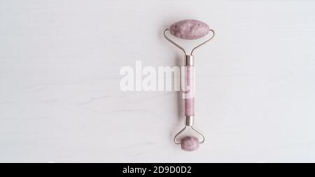 Gesichtswalze Gesichtsbehandlung Hautpflege Luxus Beauty-Tool in rosa jade Rose Quarz Gesichts Roller Banner Panorama Hintergrund mit Kopie Platz Stockfoto