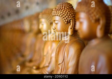 Nahaufnahme der hölzernen Buddha-Statue, im buddhistischen Tempel Nahaufnahme der hölzernen Buddha-Statue, im buddhistischen Tempel Stockfoto