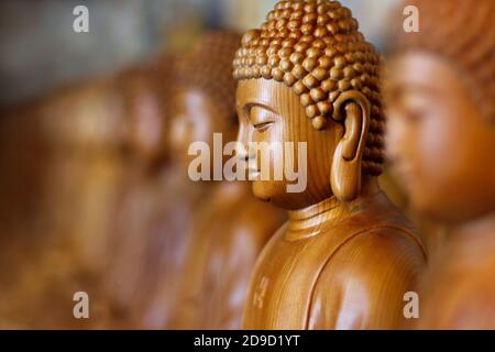 Nahaufnahme der hölzernen Buddha-Statue, im buddhistischen Tempel Nahaufnahme der hölzernen Buddha-Statue, im buddhistischen Tempel Stockfoto