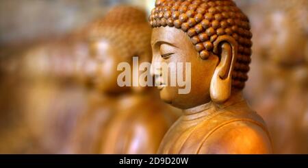 Nahaufnahme der hölzernen Buddha-Statue, im buddhistischen Tempel Nahaufnahme der hölzernen Buddha-Statue, im buddhistischen Tempel Stockfoto