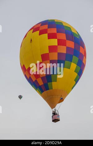 Albuquerque, New Mexico / USA - 8. Oktober 2014: Zwei Heißluftballons erheben sich beim Balloon Fiesta in Albuquerque, NM, in einen wolkenlosen Morgenhimmel. Stockfoto
