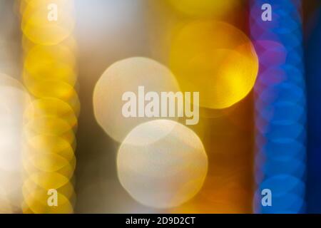 Heller unscharf abstrakter, unscharfem Bokeh-Hintergrund. Weihnachten Ornament Dekorationen gelb und blau Farbe. Außerhalb des Fokus Urlaub Happy New Year Lights, m Stockfoto