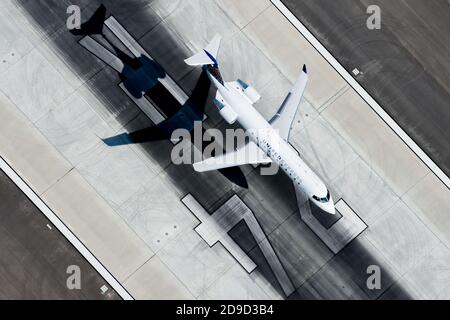 United Airlines (Sky Express) Bombardier CRJ 200 landet am Flughafen Los Angeles. United Express Flugzeug Luftbild mit Runway 24R Marken hinter. Stockfoto