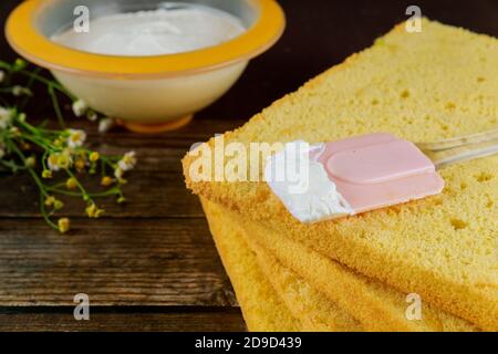 In Scheiben geschnittener Kuchen und Sahne. Vorbereitung für festliche Kuchen. Nahaufnahme. Stockfoto