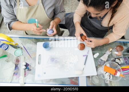 Draufsicht auf die Hände der Frauen Konditorinnen arbeiten Mit Fondant, um einen Kuchen zu dekorieren - Hände Formen Ton Mit Werkzeugen und Färbung - Frauen Handwerker Stockfoto