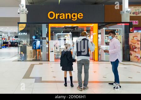 Valencia, Spanien. November 2020. Menschen mit Gesichtsmaske sprechen vor dem Orange Mobile Shop im Osito La Eliana Einkaufszentrum. Kredit: Xisco Navarro/SOPA Images/ZUMA Wire/Alamy Live Nachrichten Stockfoto