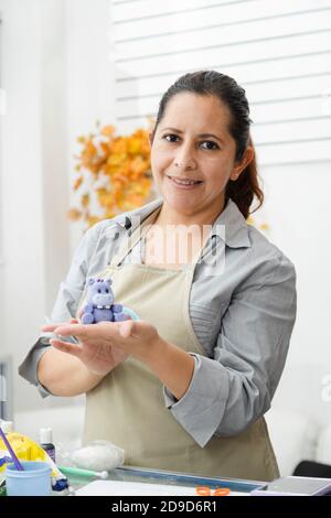 Hispanische Frau, die in ihrer Konditorei arbeitet - Latina Frau Arbeiten mit Fondant, um einen Kuchen zu dekorieren - Unternehmer Gebäck Koch - Frau, die Handwerk mit Stockfoto