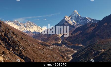 Spektakulärer Panoramablick auf das Sherpa-Dorf Pangboche (Panboche) im Tal unter dem majestätischen schneebedeckten Berg Ama Dablam und dem Mount Everest-Massiv. Stockfoto