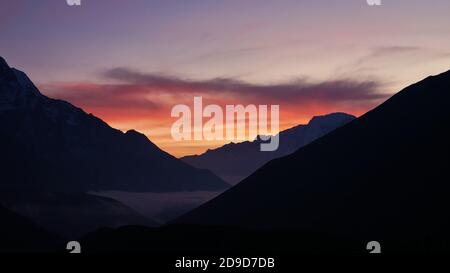 Atemberaubender Sonnenuntergang mit einem wunderschönen roten und orangefarbenen Himmel über den Himalaya Bergen von Dingboche, Khumbu Region, Himalaya, Nepal aus gesehen. Stockfoto