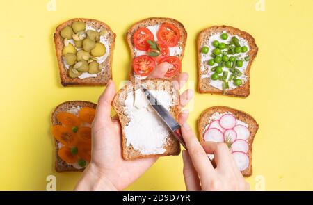 Frühstückssandwiches mit vegetarischen Füllungen Frau breitet Frischkäse Toast Stockfoto