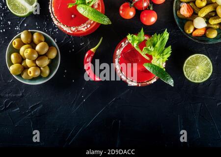 Bloody Mary Cocktail Design-Vorlage, eine flache lag auf einem dunklen Hintergrund mit einem Platz für Text. Tomatensaft und Alkoholmischung serviert mit Limette und Sellerie, von oben geschossen Stockfoto