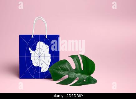 Antarctica Shopping-Konzept. National Karton Einkaufstasche mit Monstera Blatt und rosa Hintergrund. Online-Shopping-Thema. Stockfoto