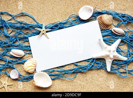 Leeres Blatt Papier auf Strandsand mit Meer Schalen Stockfoto