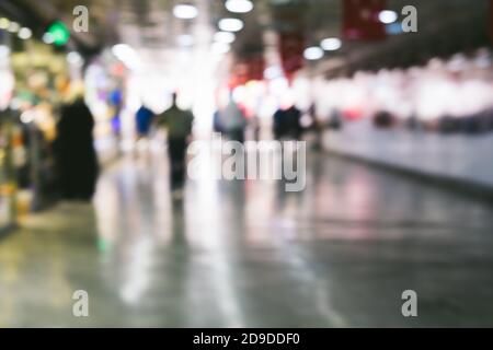 Heller unscharfer Hintergrund mit unkenntlichen Personen am Flughafen. Abstraktes Bild der Menschenmenge im öffentlichen Raum Stockfoto