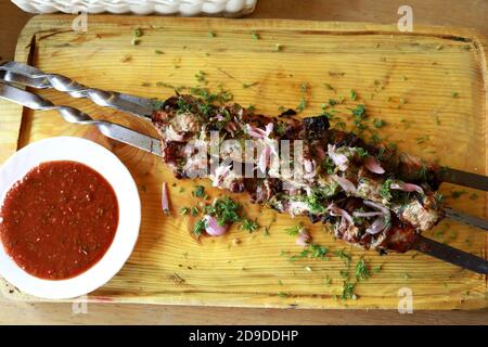 Shish Kebab auf Spieße auf Holzbrett im Restaurant Stockfoto