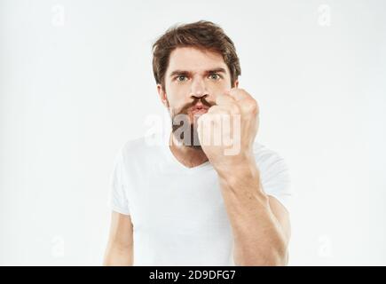 Aggressiver Mann mit den Händen auf einem hellen Hintergrund Und einen dicken Bart Stockfoto
