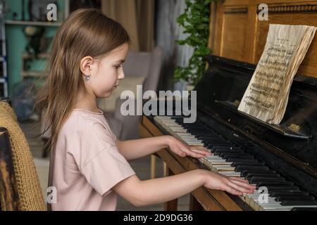 Nettes kleines Mädchen lernt, das Klavier zu spielen Stockfoto